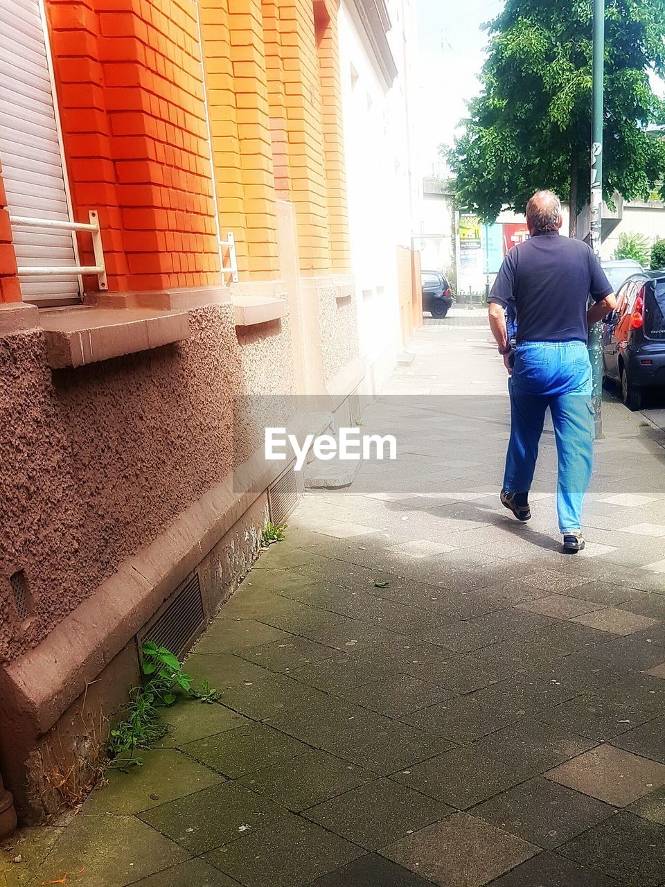 REAR VIEW OF WOMAN WALKING ON STREET