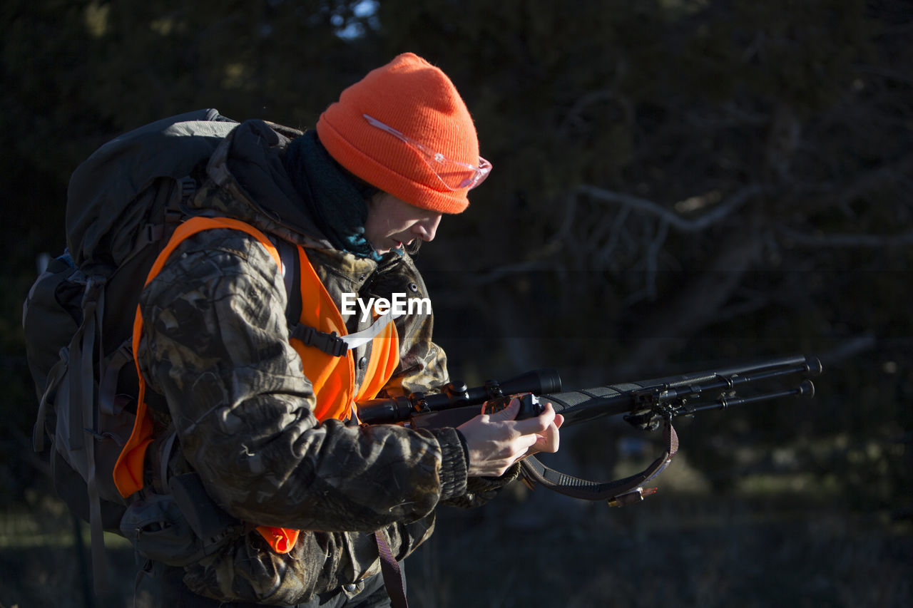 Female hunter loads her gun in paonia, colorado