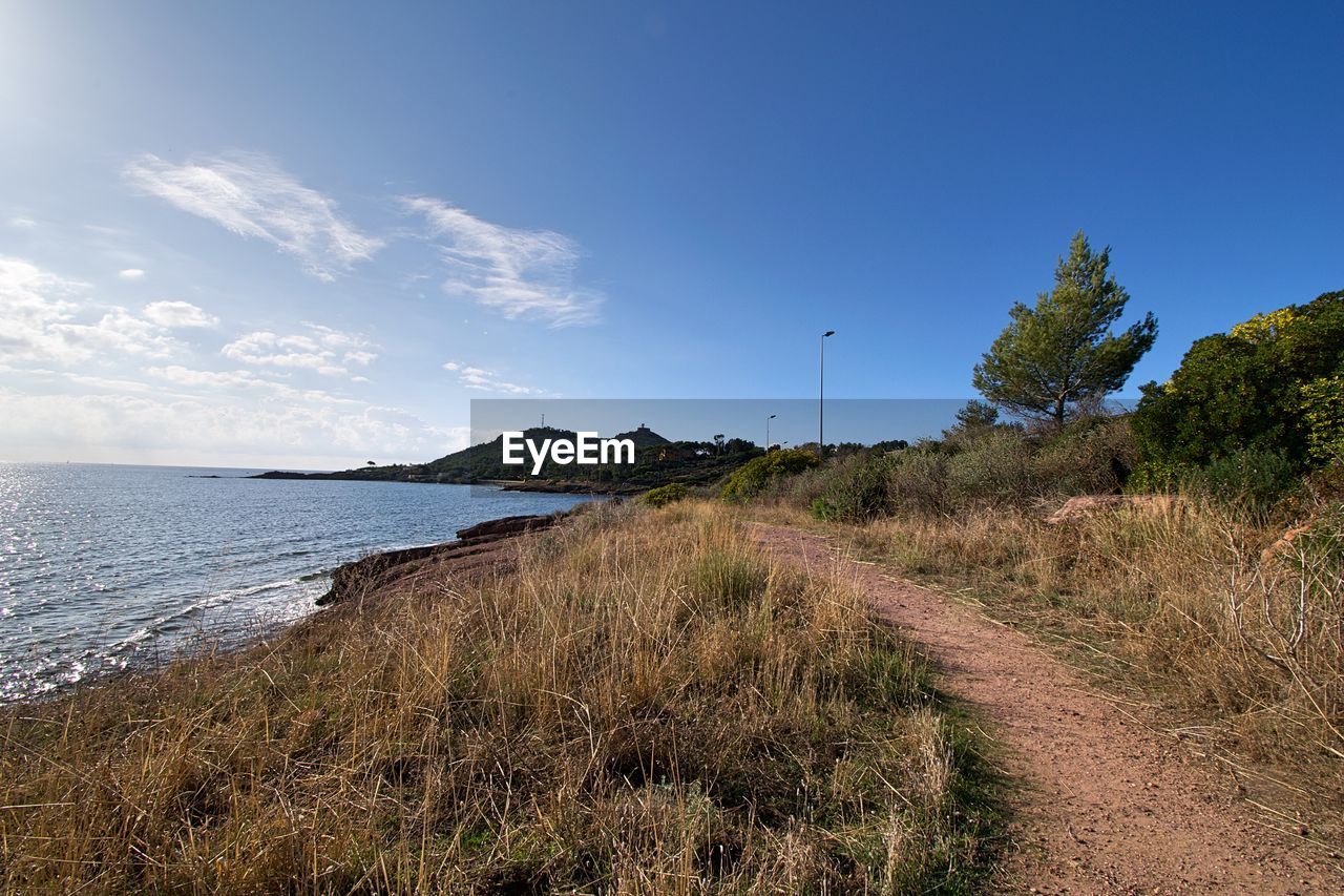SCENIC VIEW OF BEACH AGAINST BLUE SKY