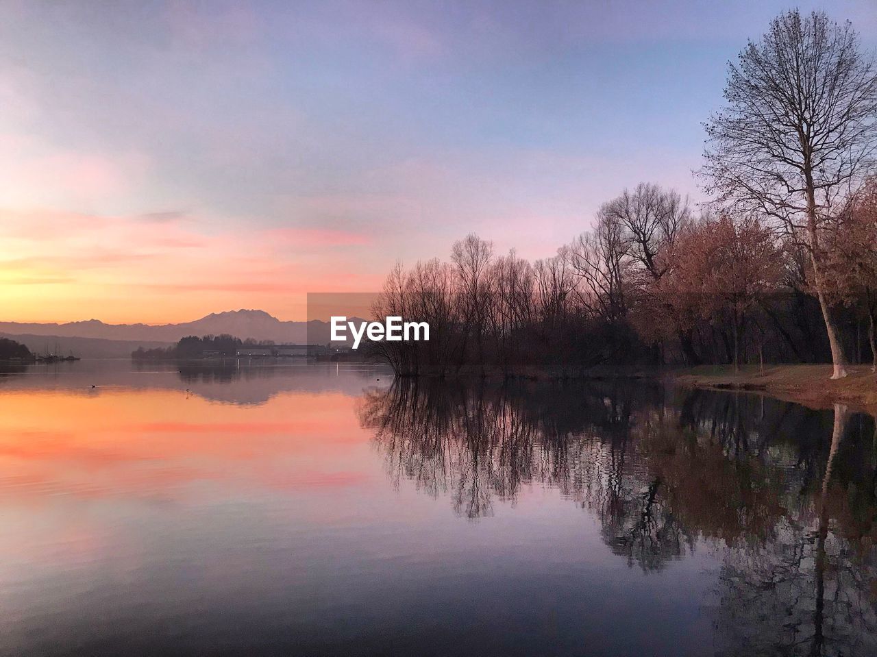 Scenic view of lake against sky at sunset