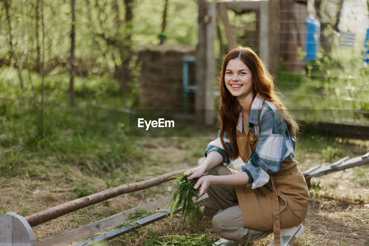 portrait of smiling young woman standing by railing