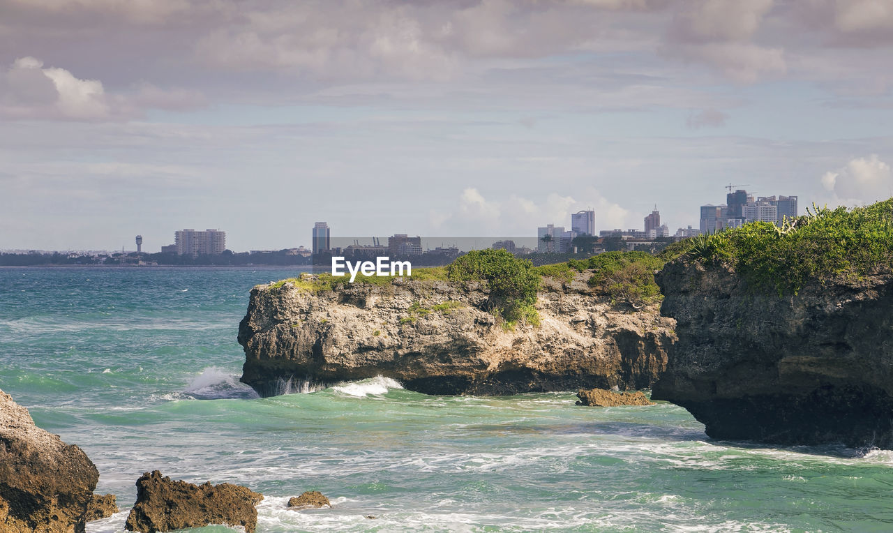 Scenic view of sea by rock formation against sky