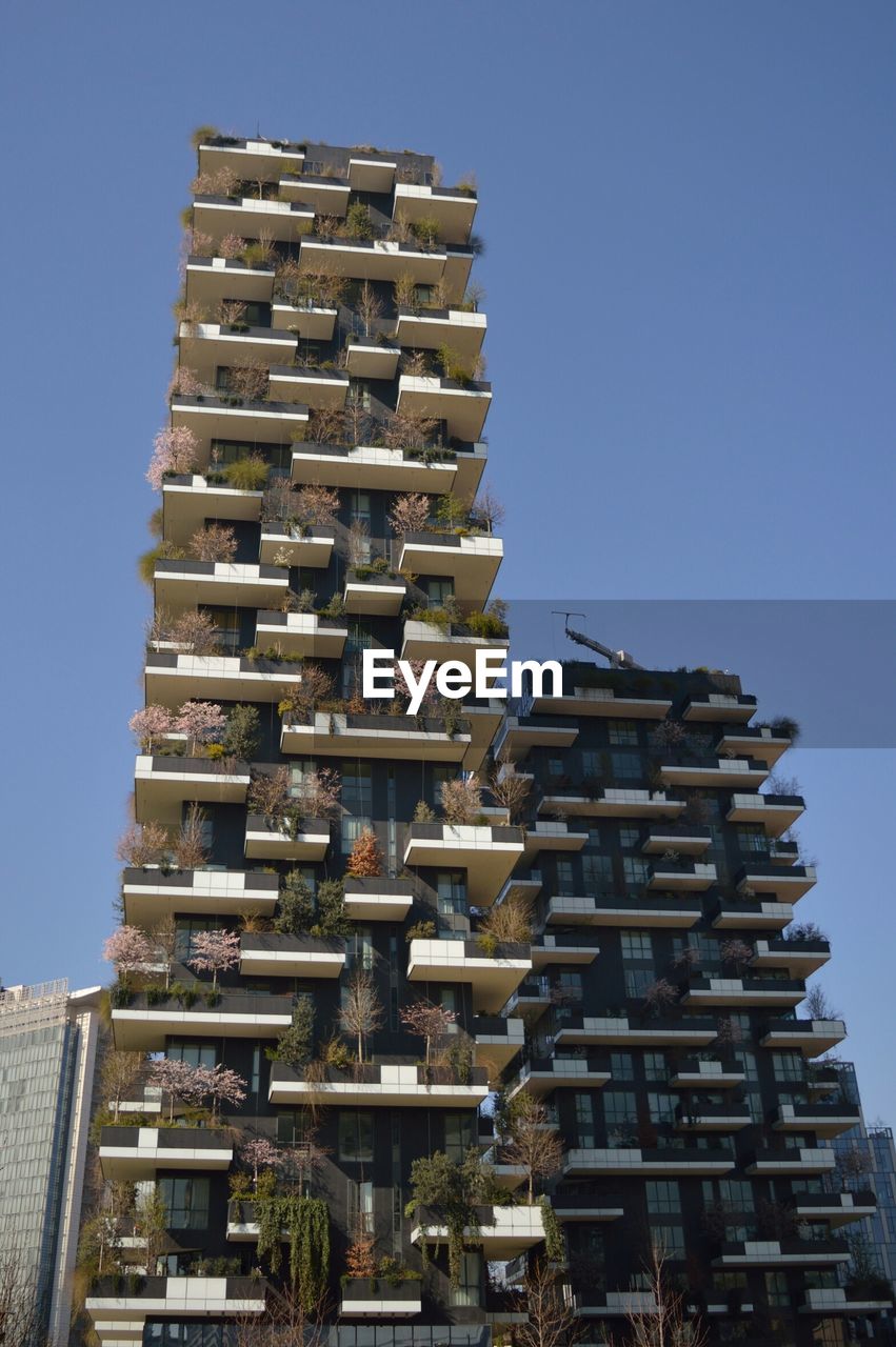 LOW ANGLE VIEW OF BUILDINGS AGAINST CLEAR BLUE SKY