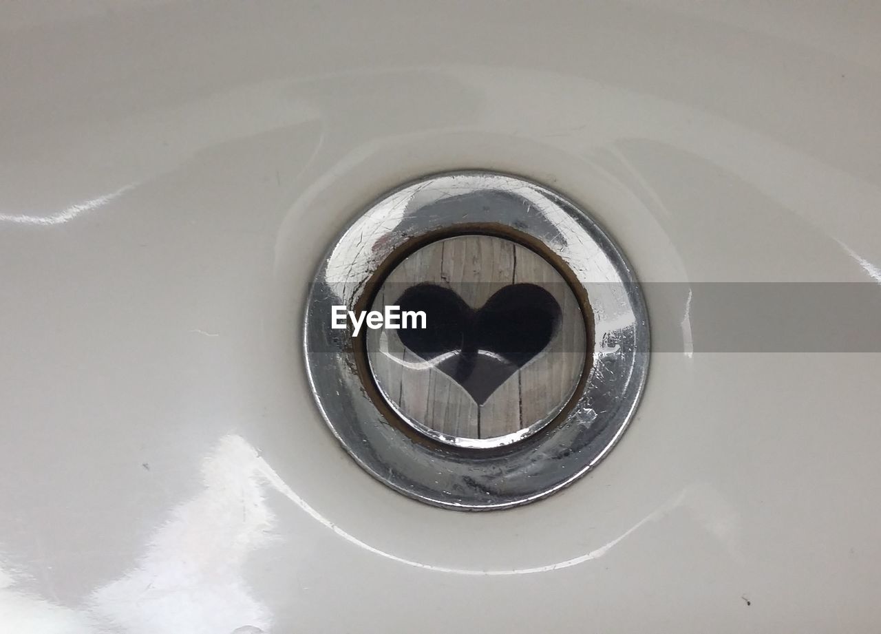 High angle view of heart shape on drain