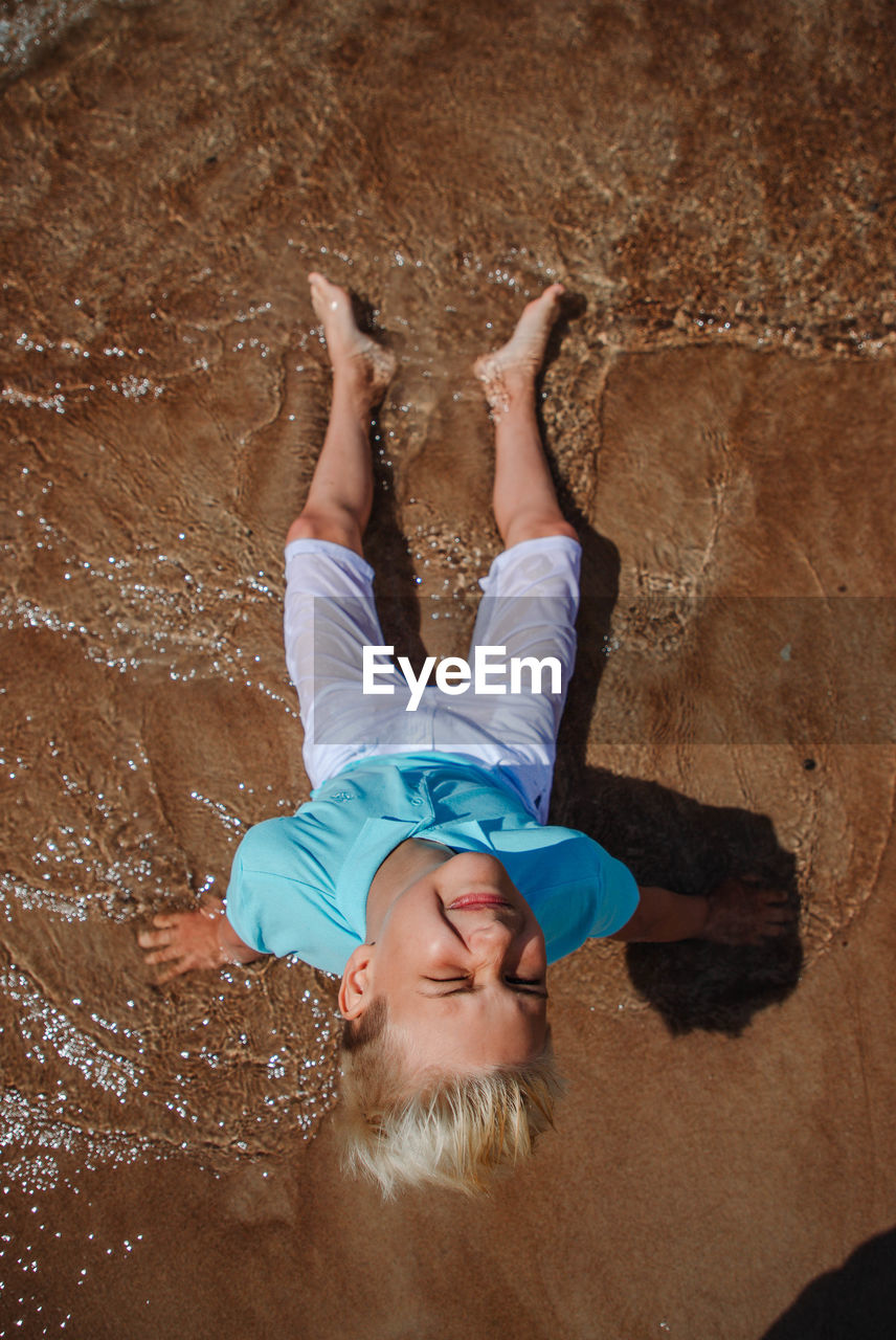 high angle view of young woman standing on rock