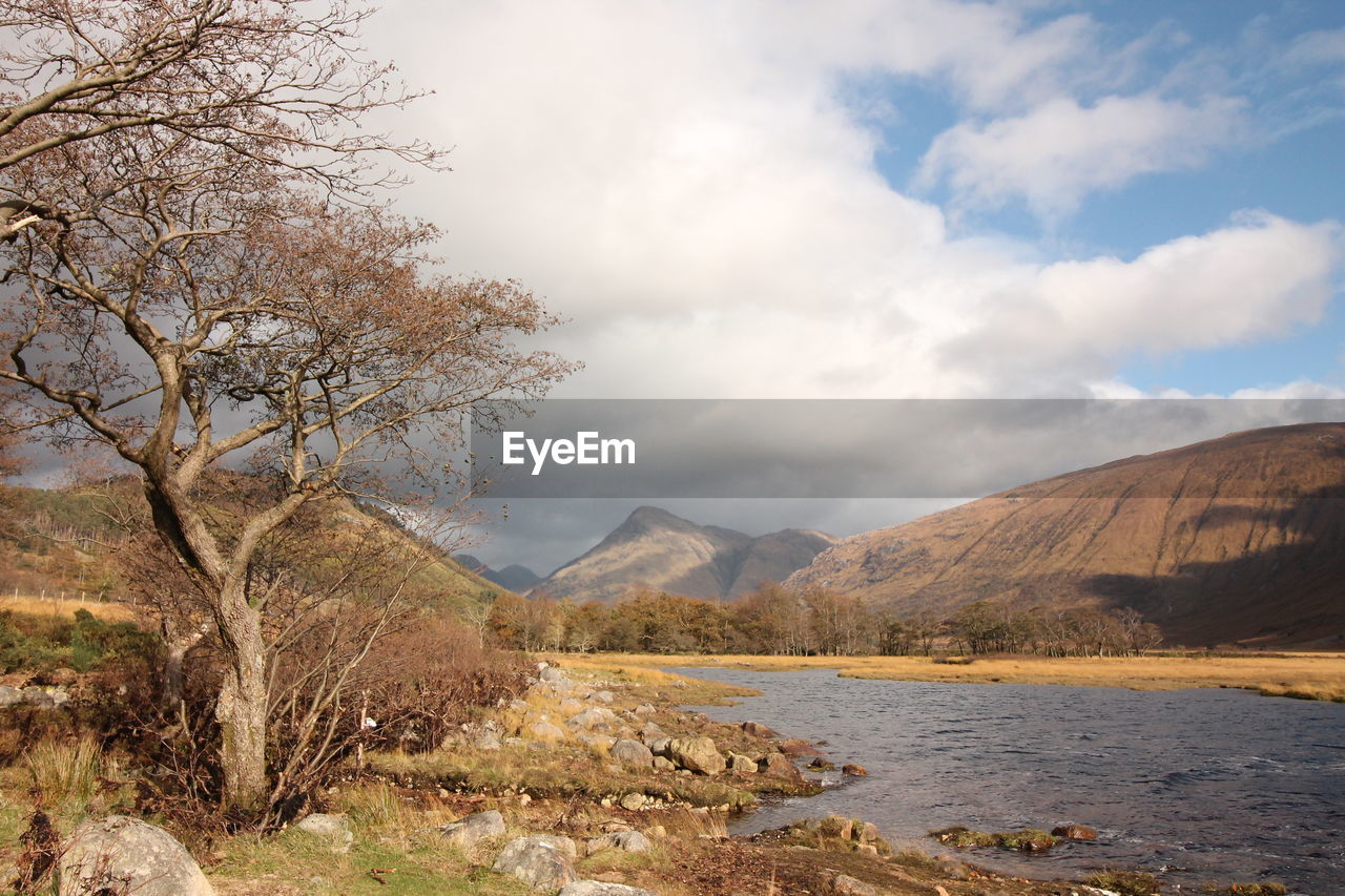 Scenic view of lake by mountains against sky