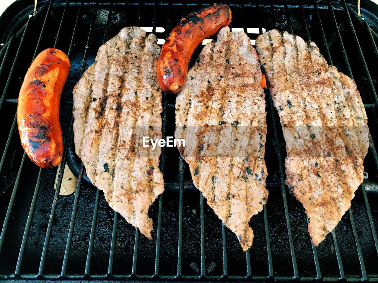 CLOSE-UP OF MEAT ON GRILL