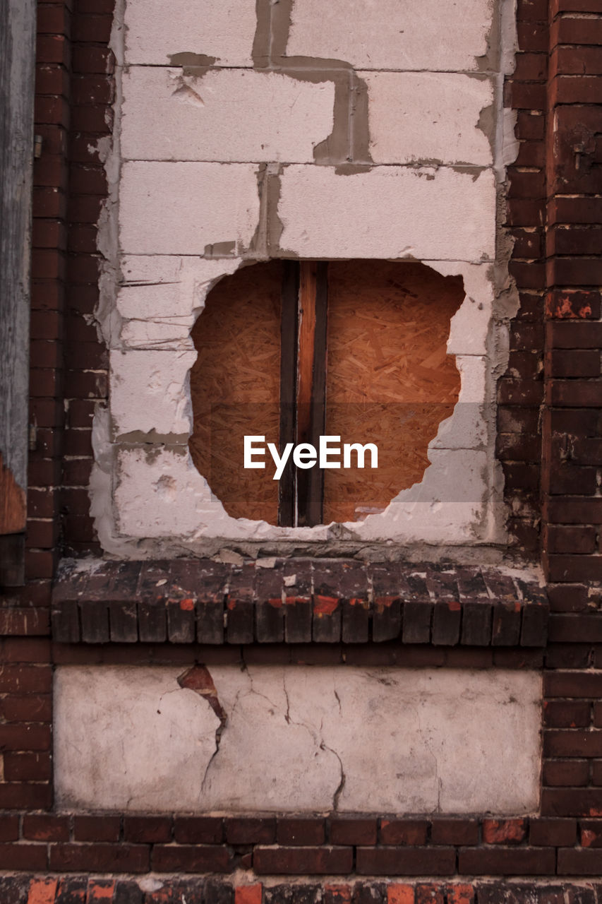 CLOSE-UP OF WEATHERED WALL WITH WINDOWS