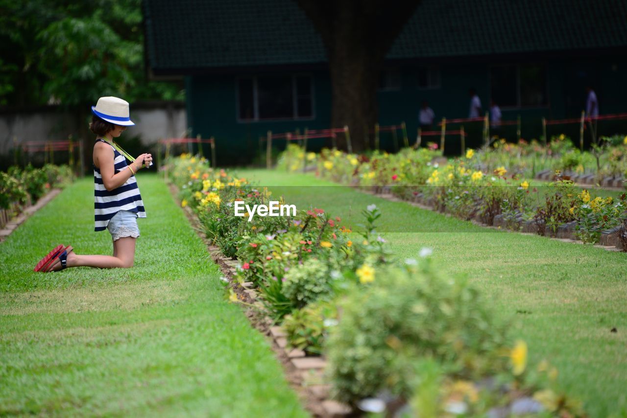 Side view of girl kneeling on grass