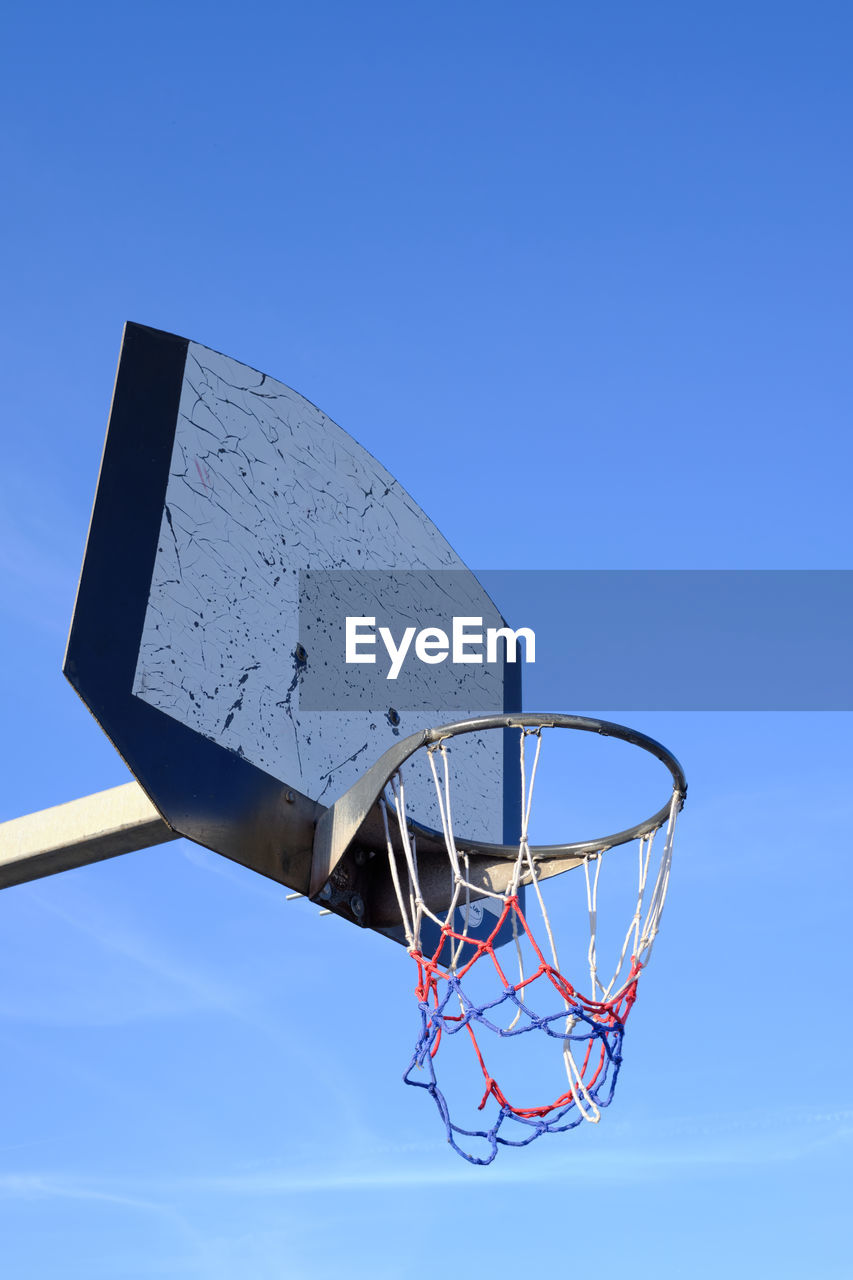 Basketball hoop and net against a blue sky. urban youth game. low angle view. .