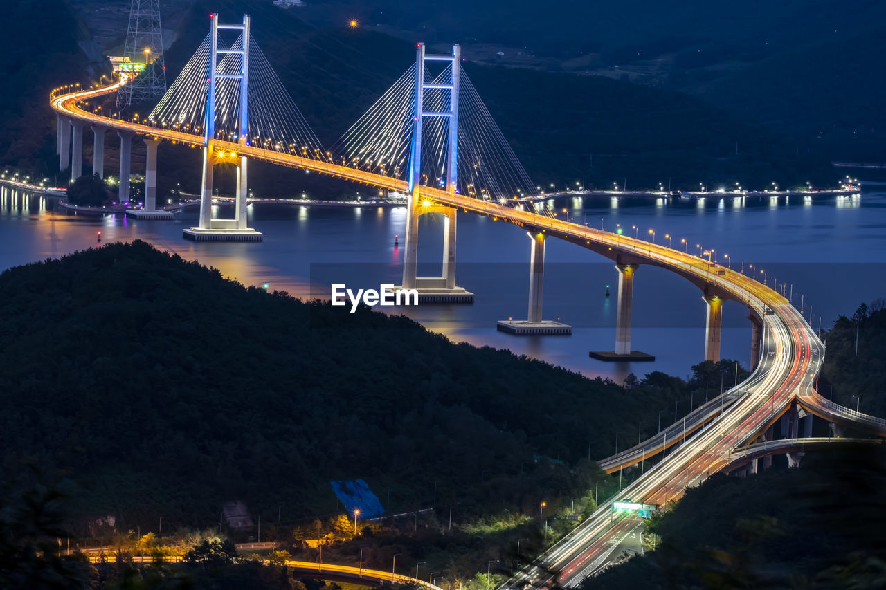 ILLUMINATED SUSPENSION BRIDGE OVER RIVER