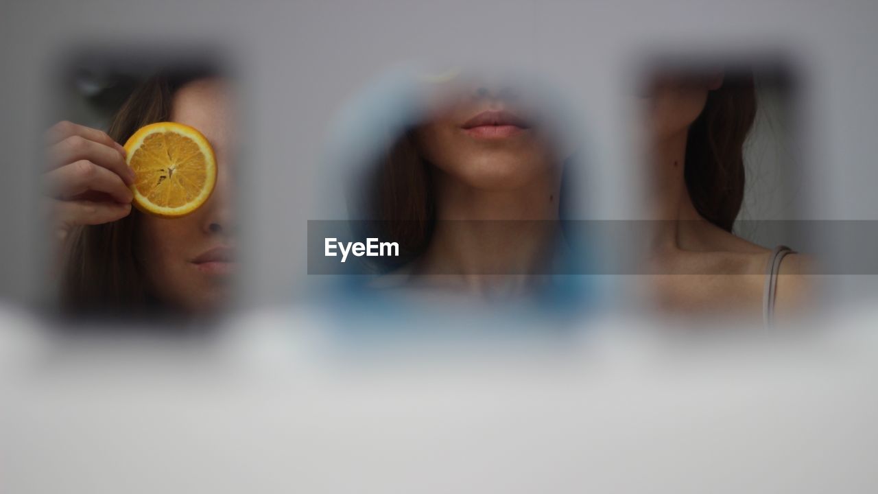 Reflection of woman covering orange slice