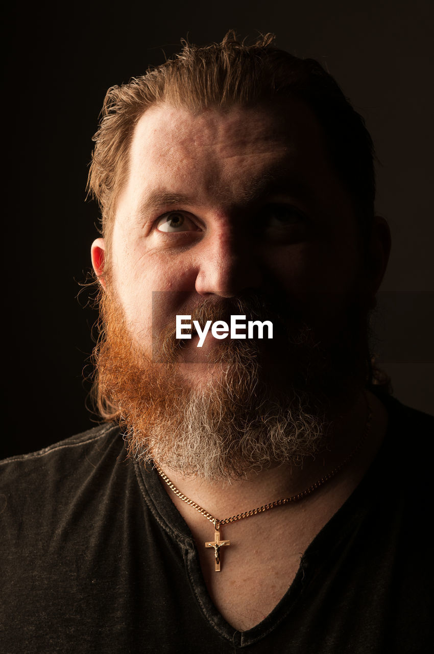 CLOSE-UP PORTRAIT OF MAN WITH FACE AGAINST BLACK BACKGROUND