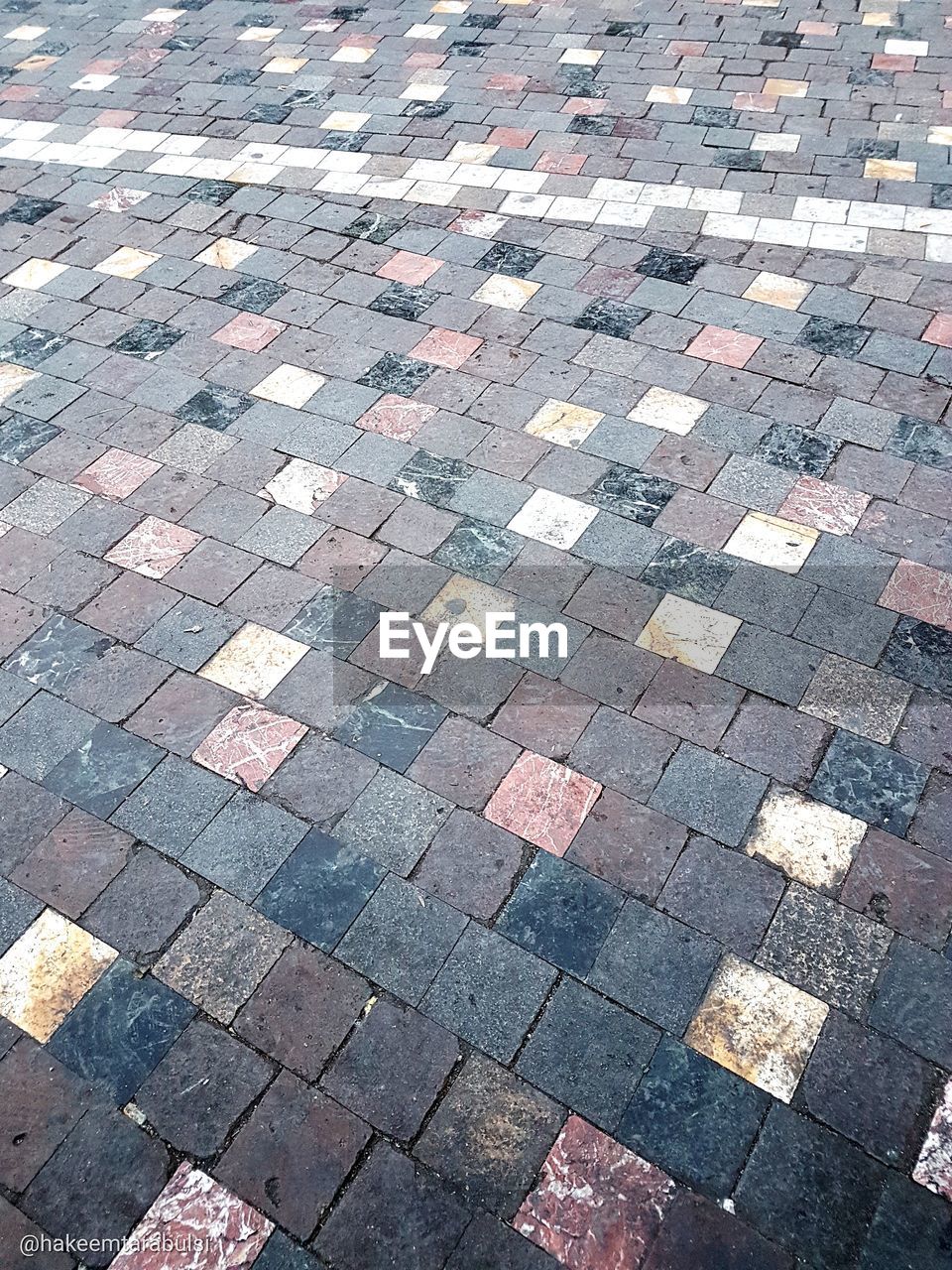 HIGH ANGLE VIEW OF COBBLESTONE STREET IN CITY