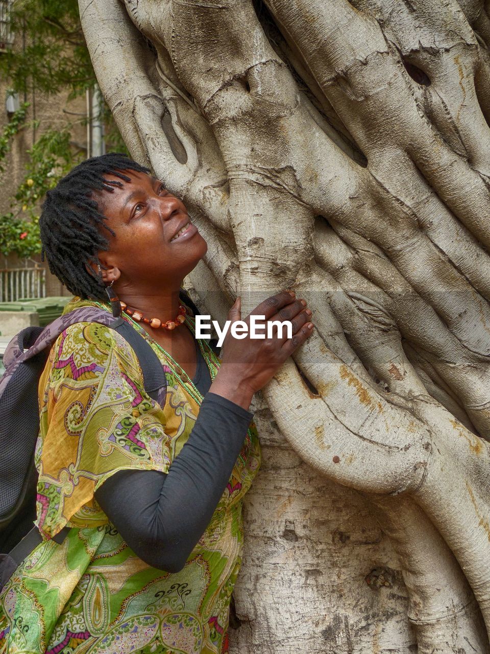 Close-up of woman standing by tree trunk