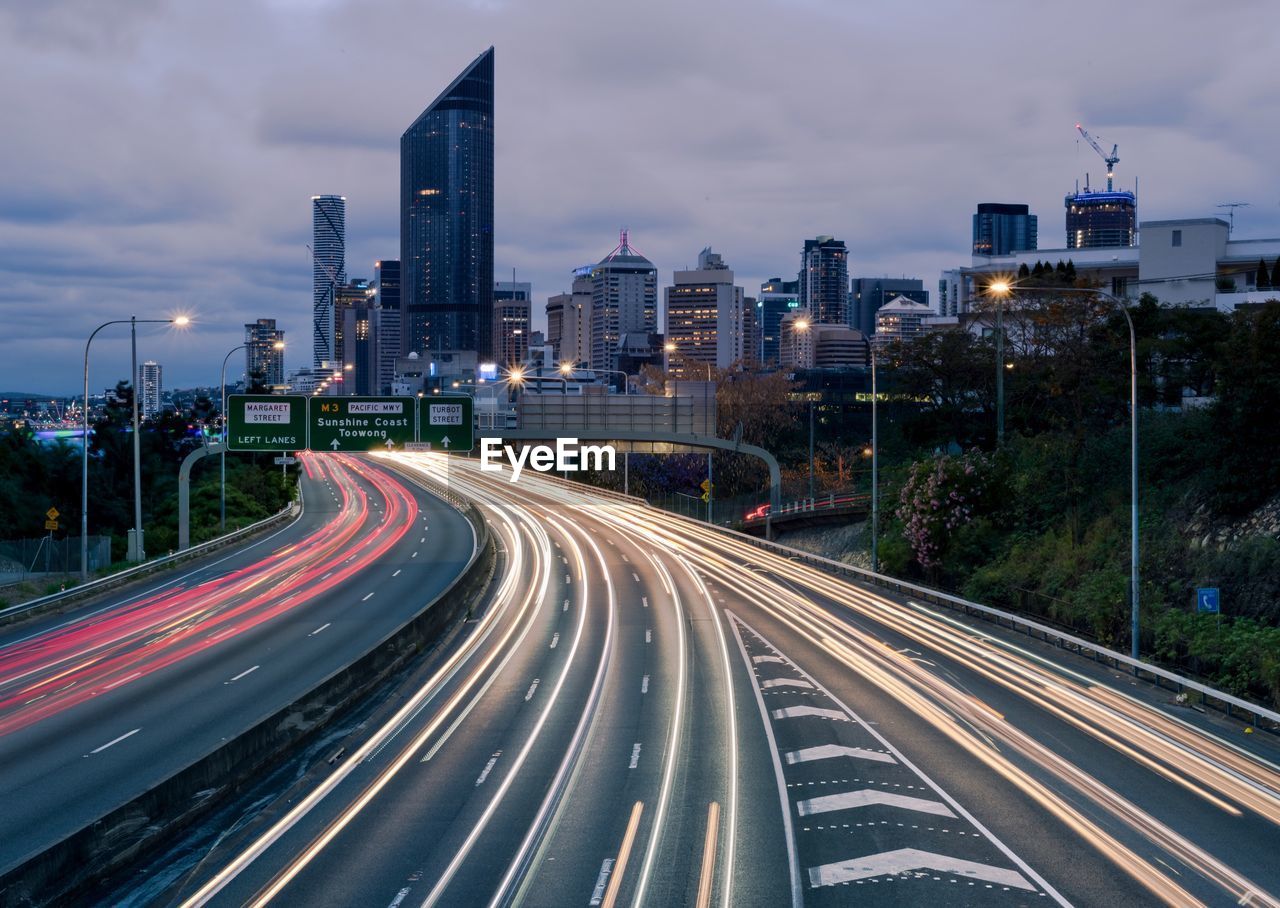 Light trails on road along buildings at night