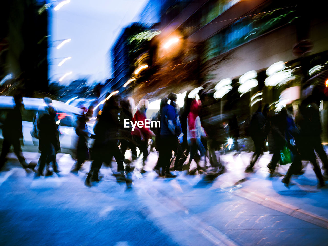 Blurred motion of people crossing street during winter