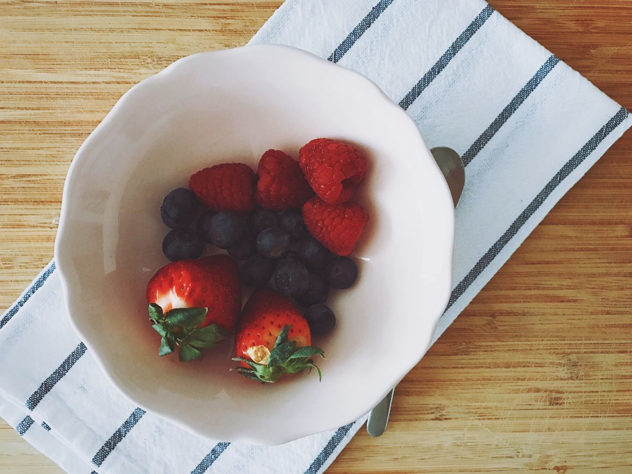 Directly above shot of fruits in bowl with napkin on table