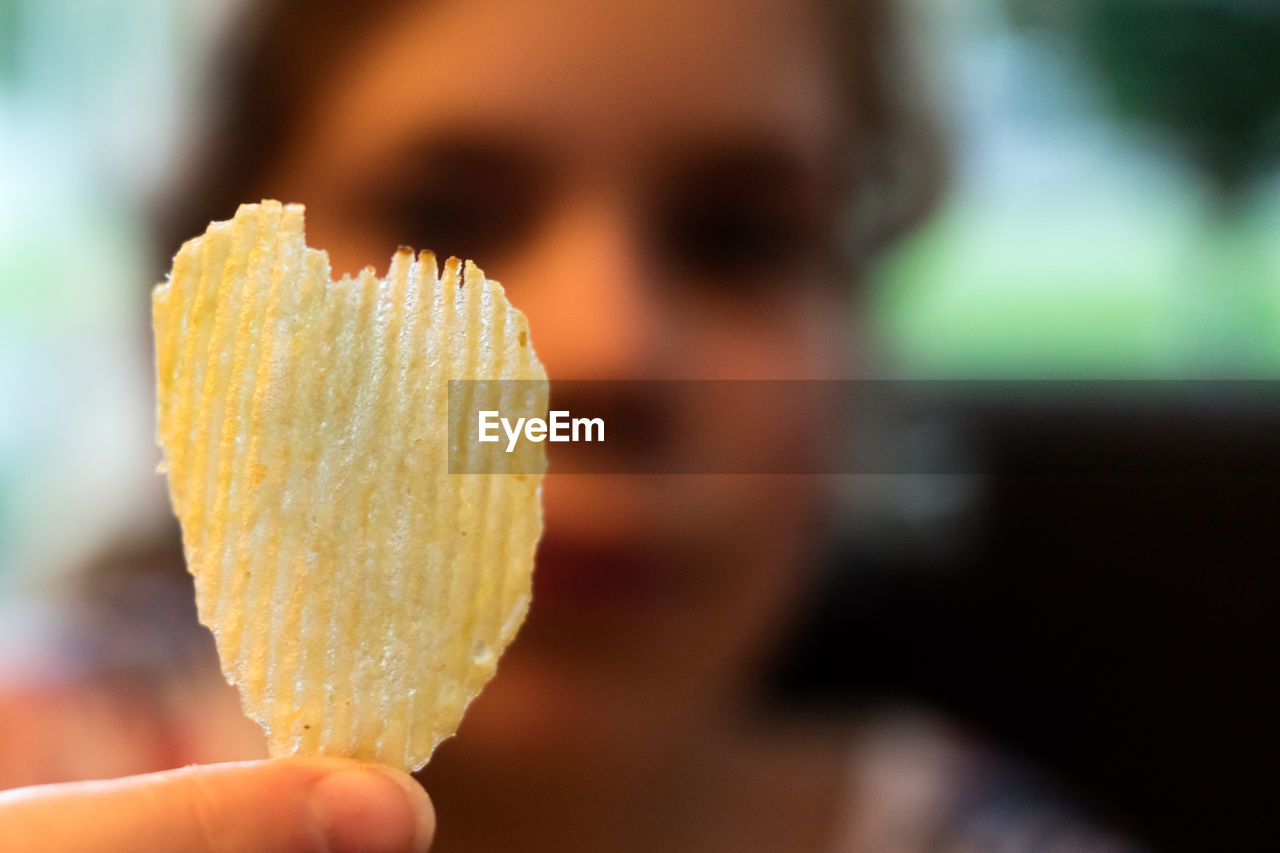 Woman holding heart shape potato chip