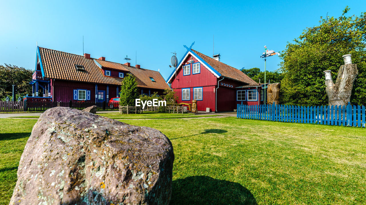 HOUSE ON FIELD AGAINST CLEAR SKY