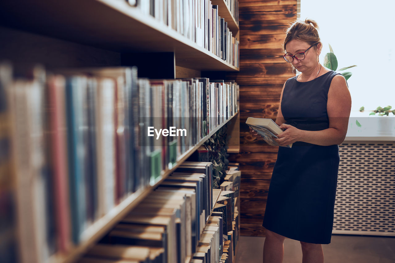 Woman reading book in public library. reading and learning. benefits of everyday reading. bookstore