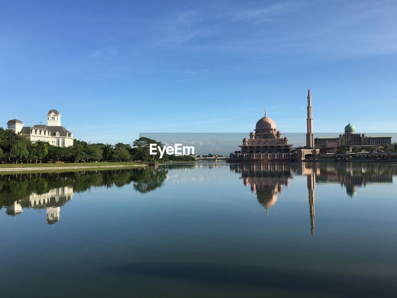 Reflection of putra mosque in lake against sky in city