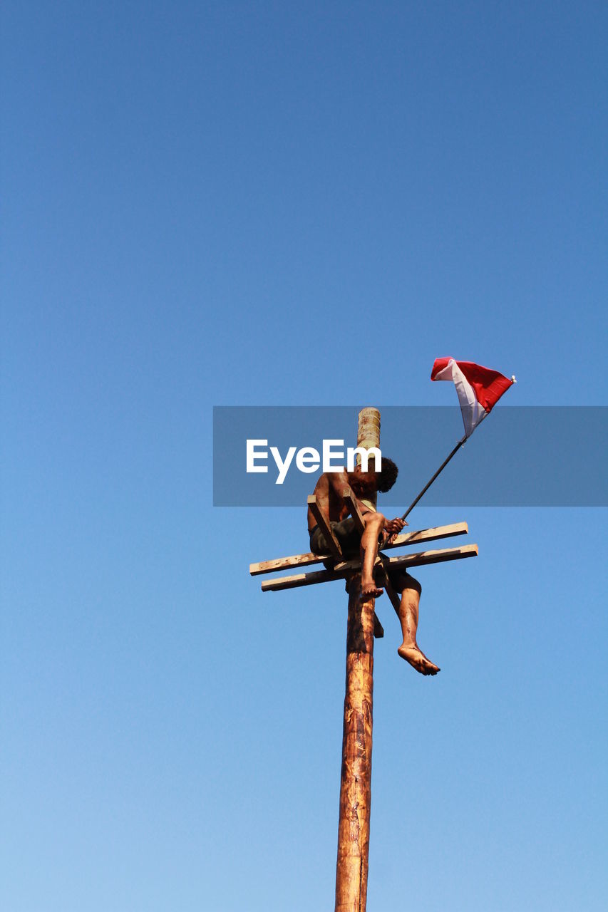 LOW ANGLE VIEW OF FLAGS AGAINST CLEAR SKY