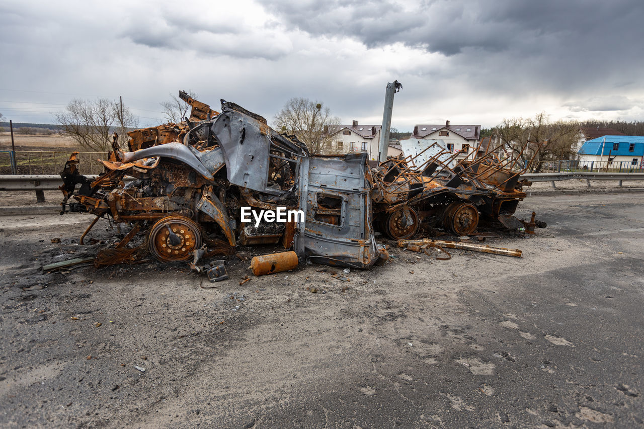 Burnt military vehicles of russian soldiers on the bridge across the river. rusty cars.