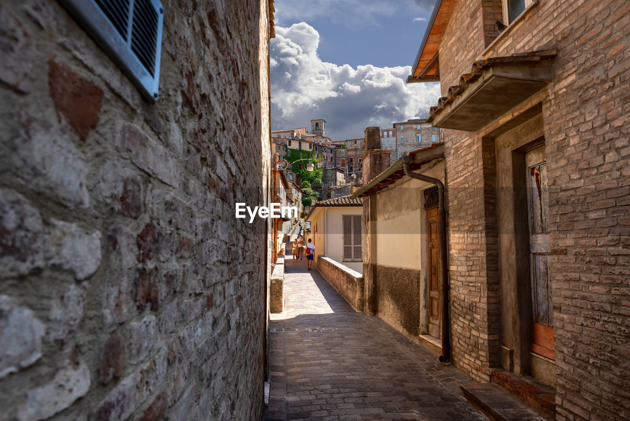 ALLEY AMIDST BUILDINGS AGAINST SKY