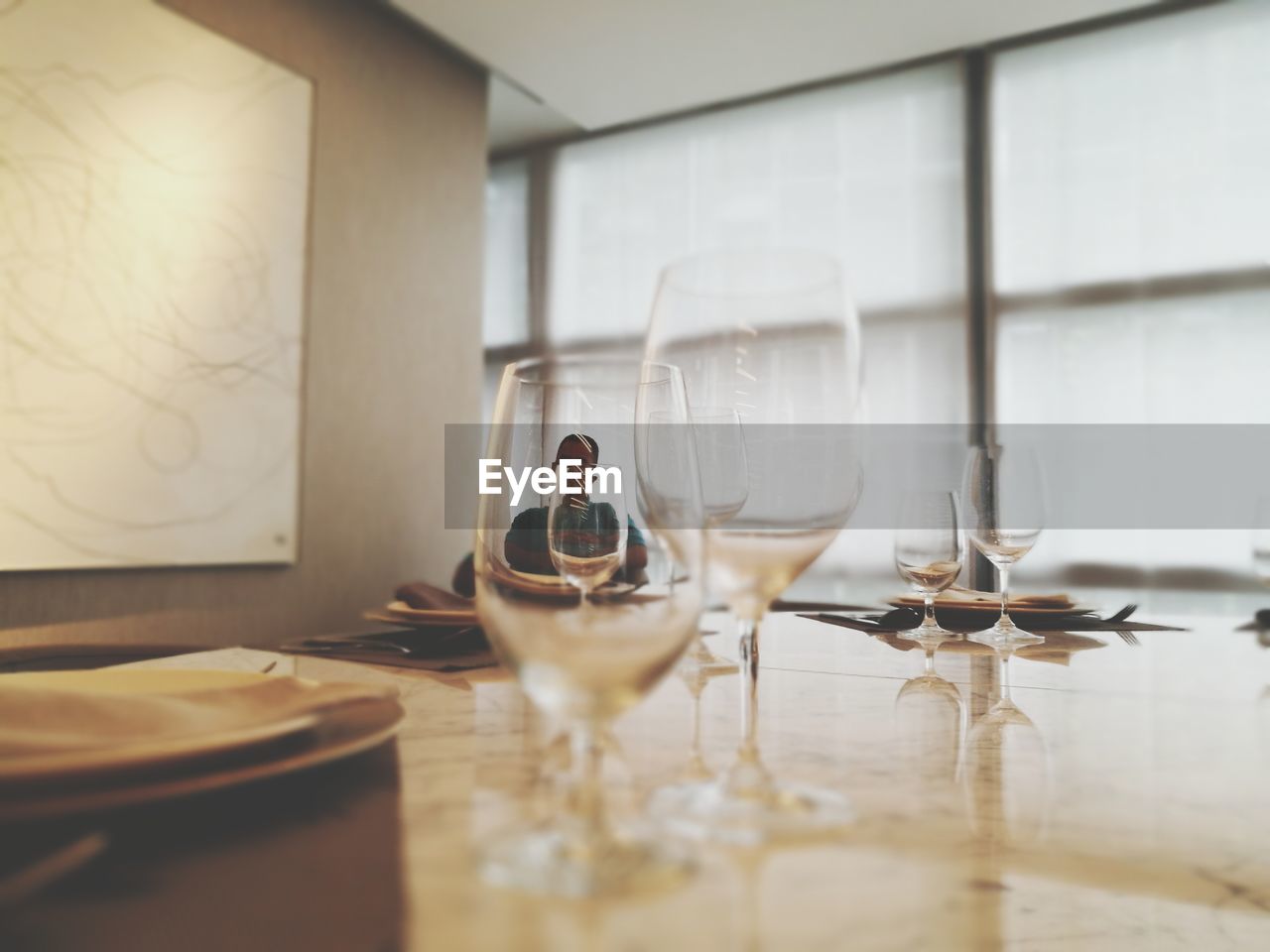 Man sitting in restaurant seen through glasses