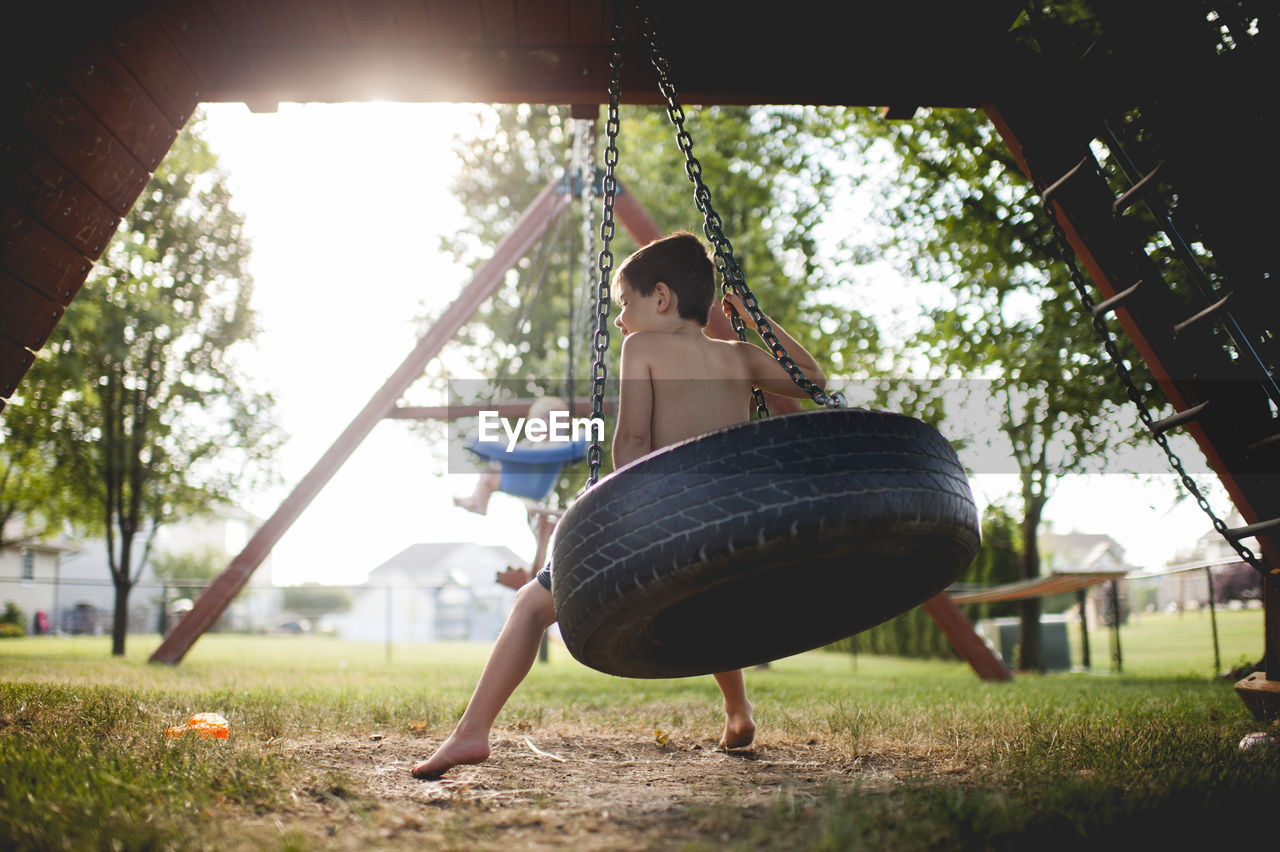 Brothers swinging at playground