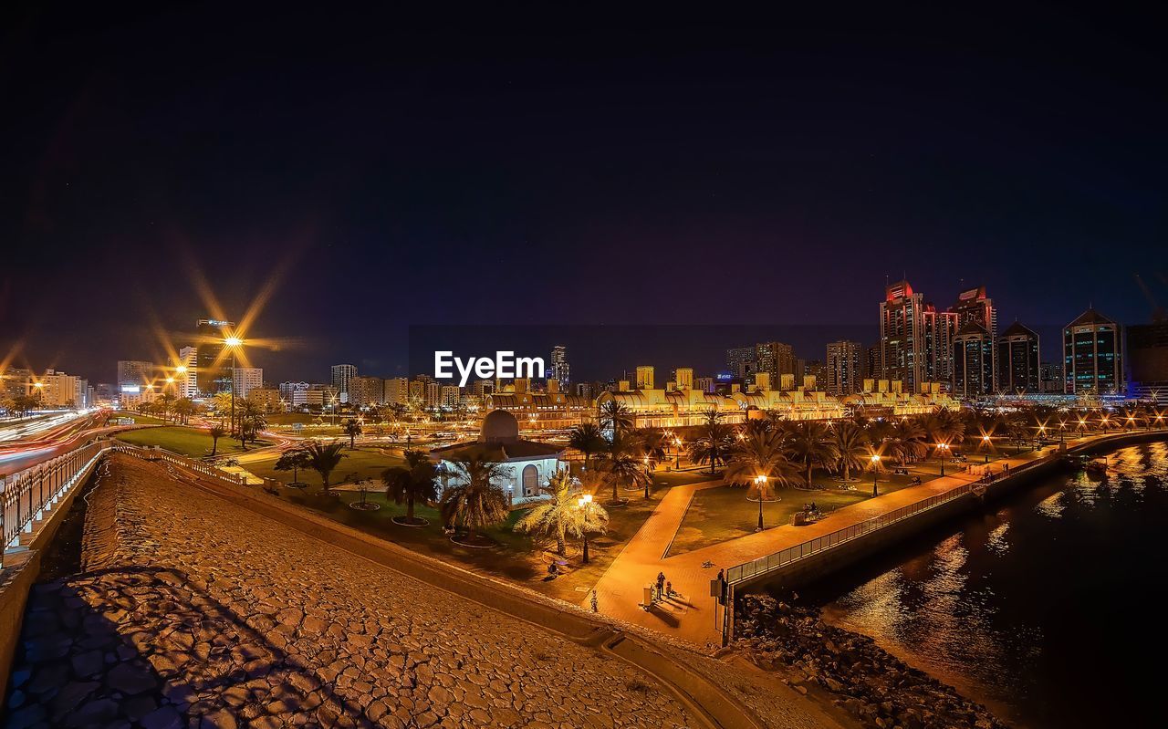 ILLUMINATED CITYSCAPE AGAINST SKY AT NIGHT