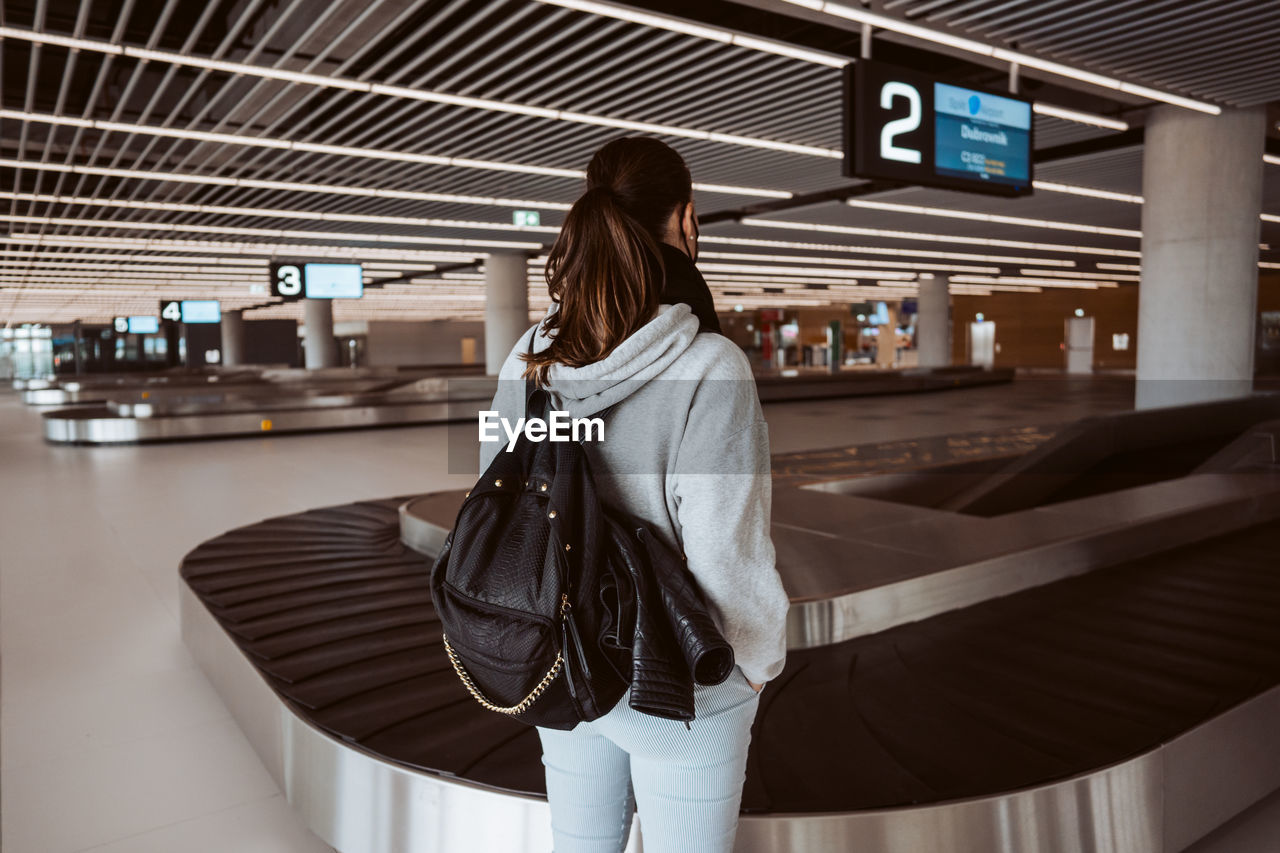 Rear view of young woman standing in city