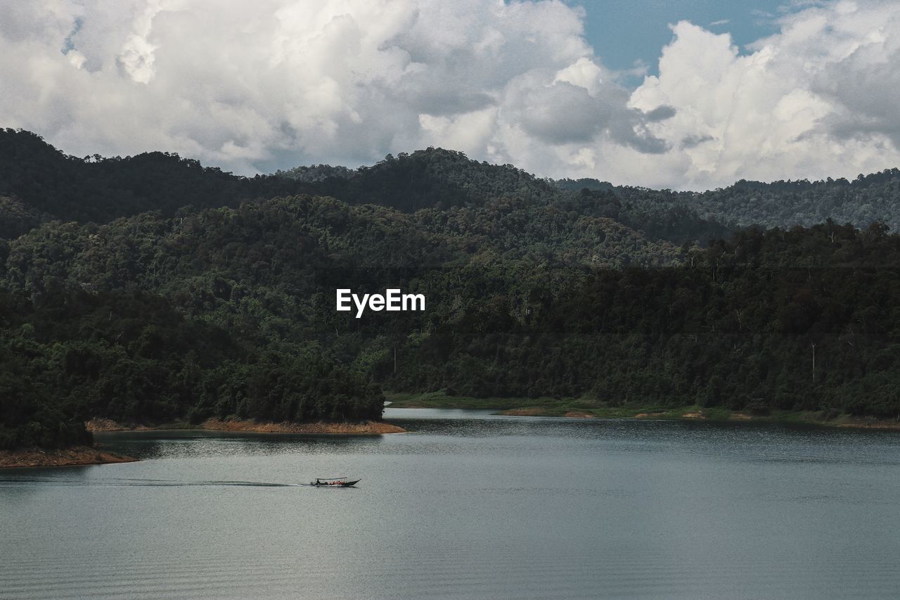 Scenic view of lake by trees against sky