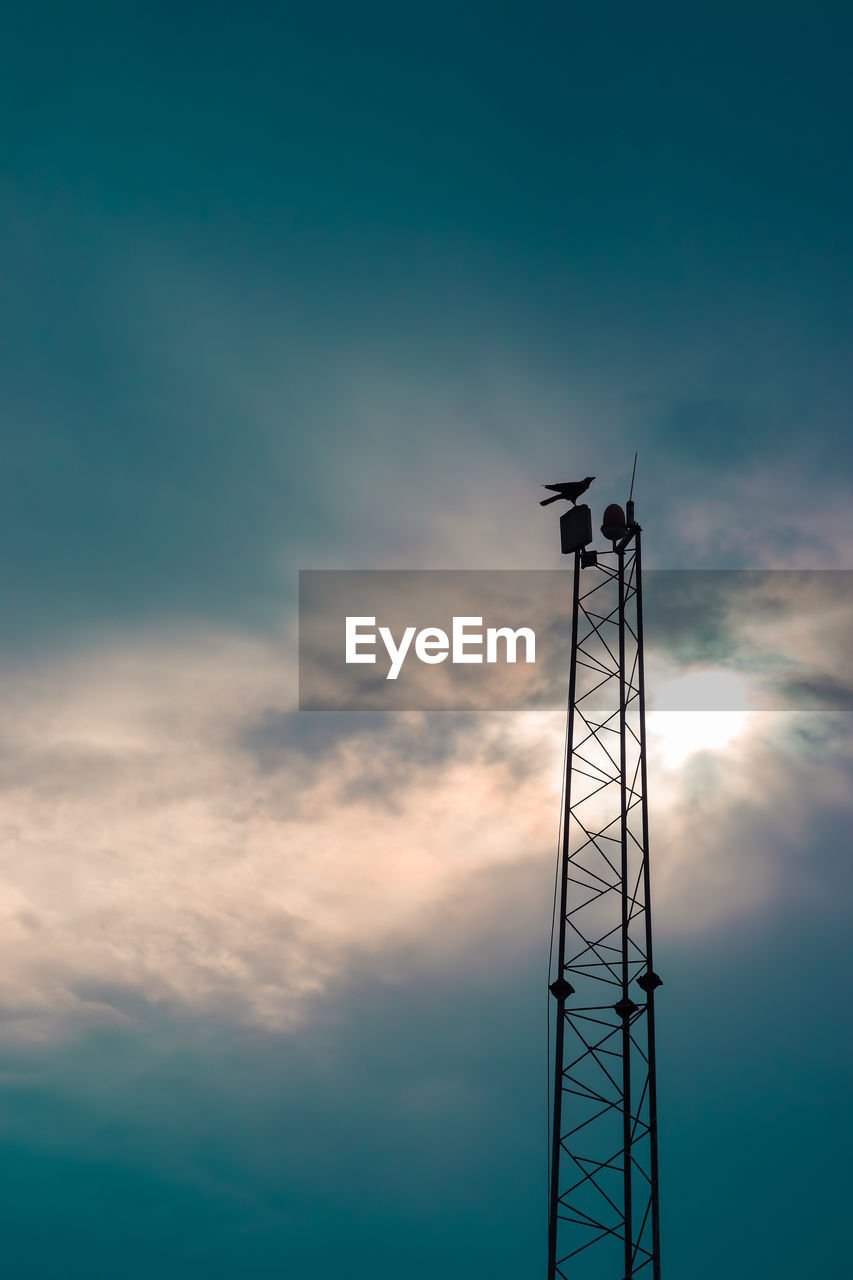 Low angle view of communications tower against sky during sunset