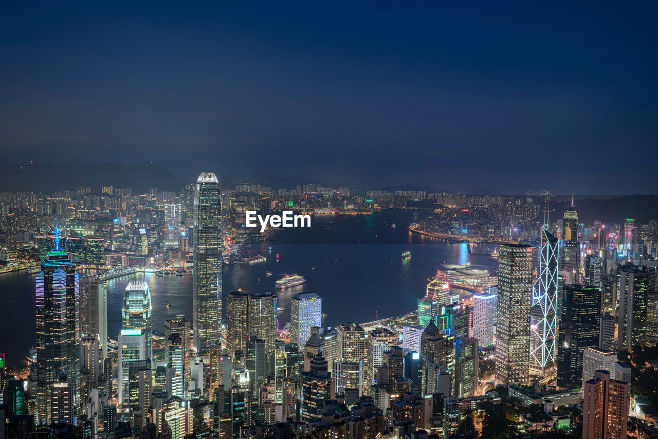 Illuminated cityscape against sky at night