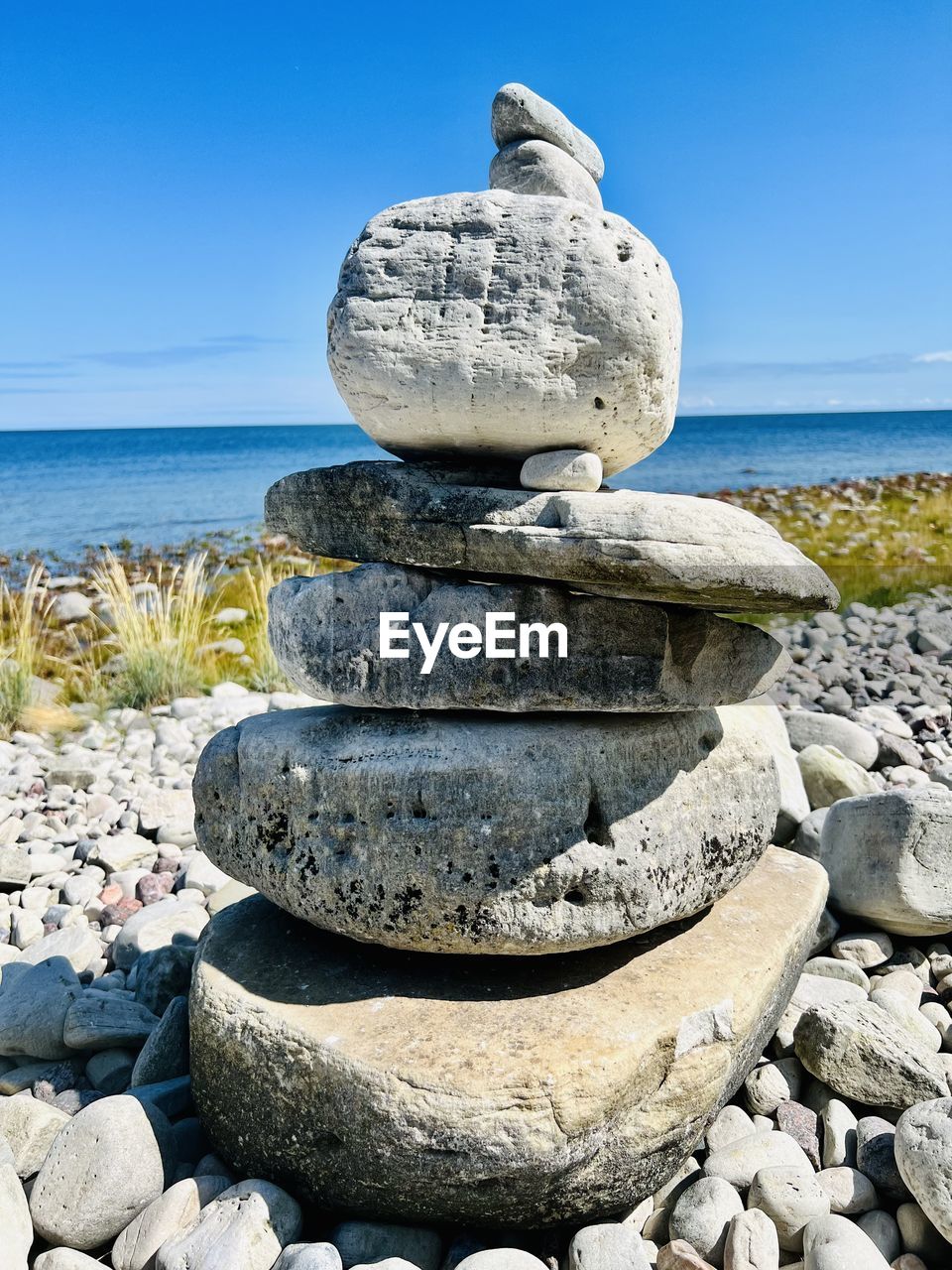 rock, sea, water, shore, beach, sky, stone, nature, coast, pebble, land, zen-like, ocean, tranquility, no people, clear sky, balance, sand, tranquil scene, boulder, blue, beauty in nature, scenics - nature, day, horizon over water, vacation, horizon, outdoors, sunny, travel destinations, sunlight, travel, body of water