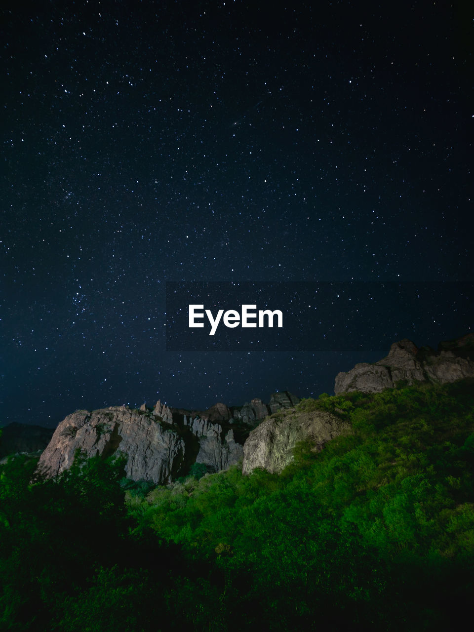 low angle view of man standing on mountain against sky at night