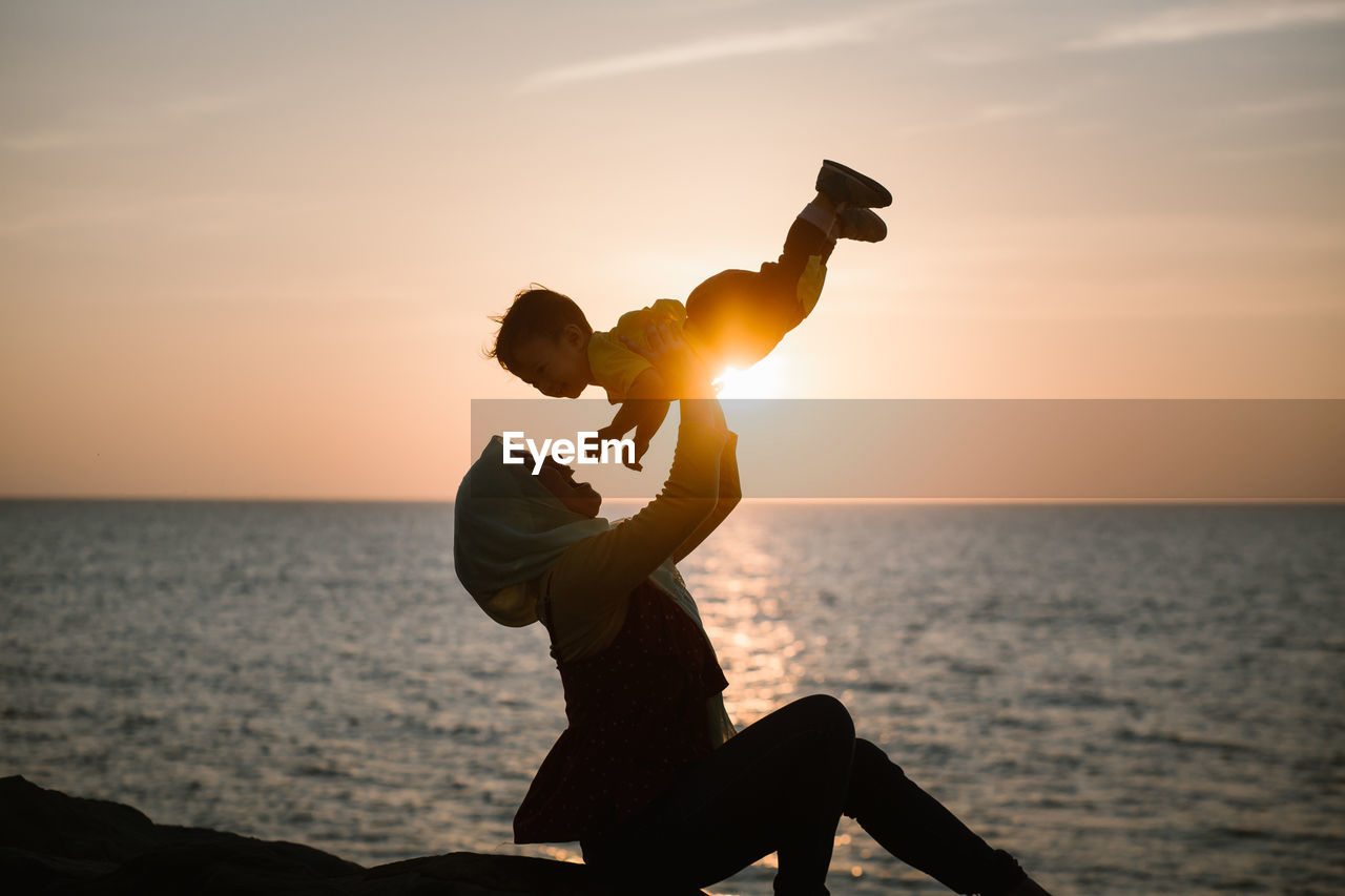 Silhouette man against sea during sunset