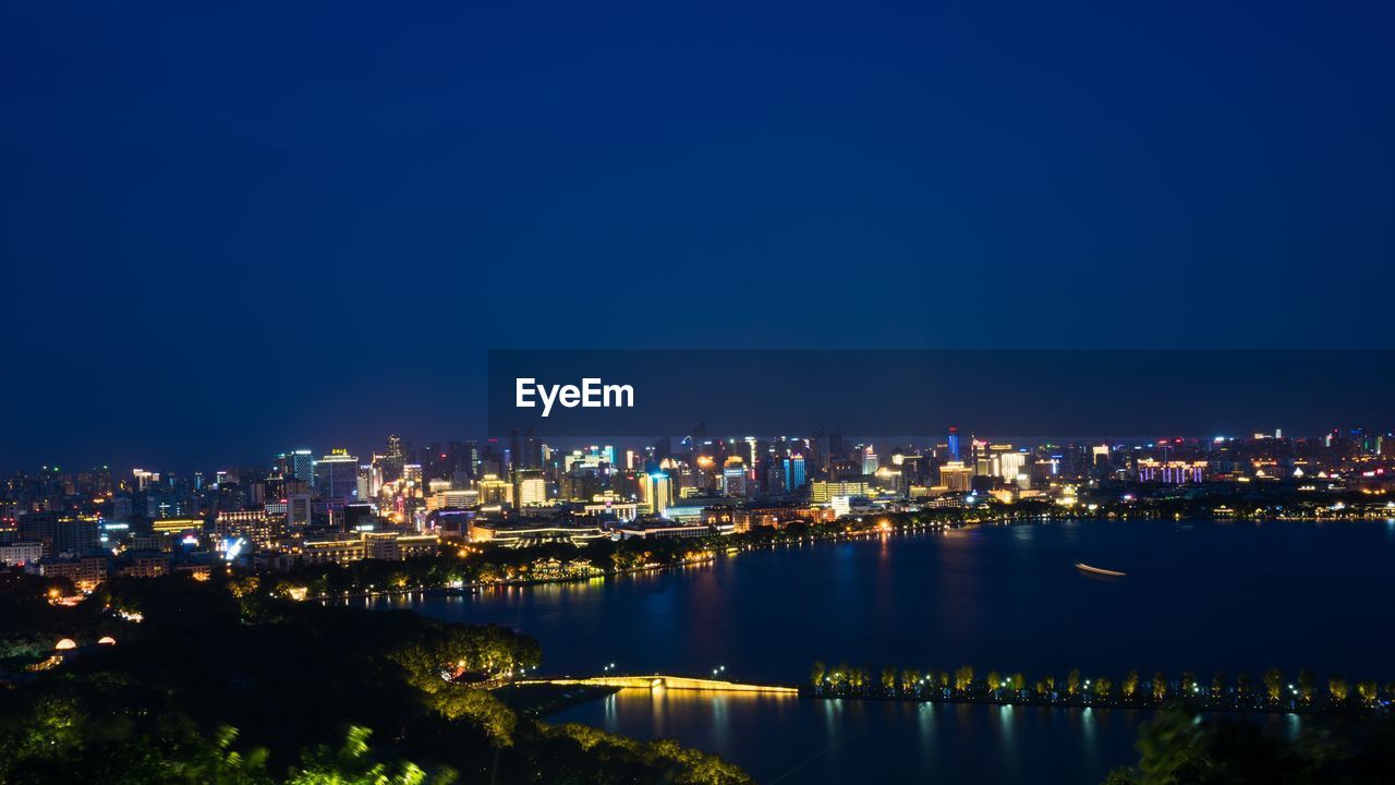 Illuminated cityscape against clear sky at dusk