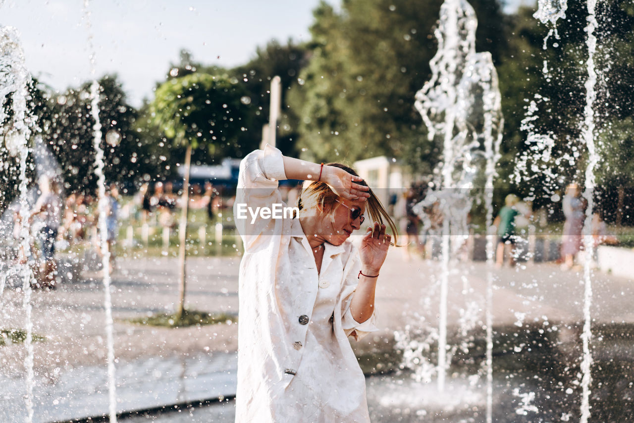Young woman enjoying at water fountain