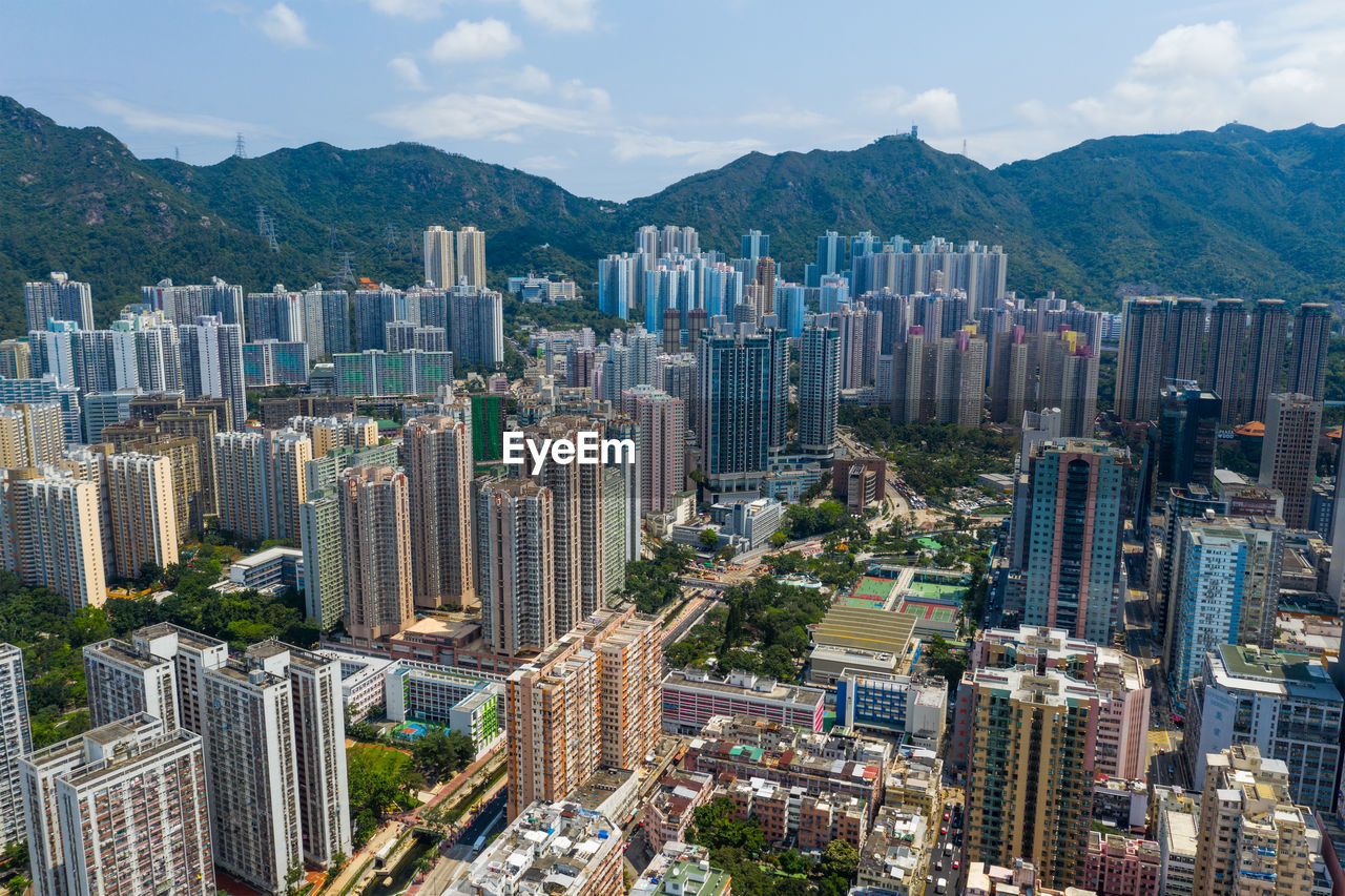 Aerial view of buildings in city against sky