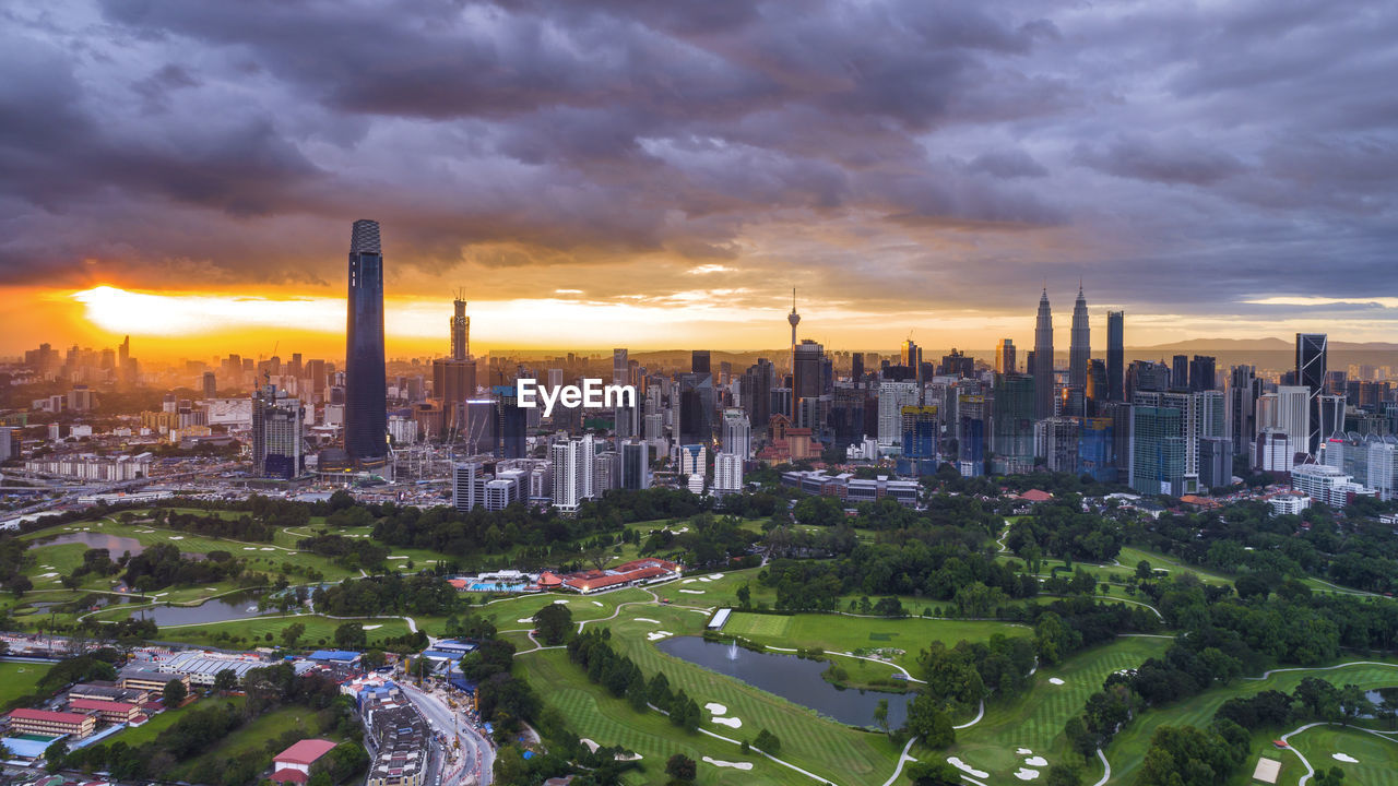 AERIAL VIEW OF BUILDINGS AGAINST CLOUDY SKY