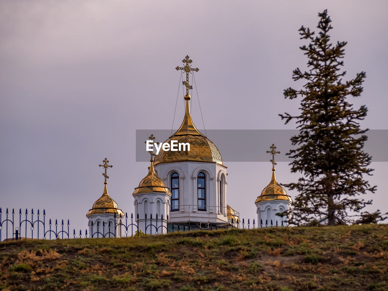 Golden domes of an orthodox church against the background of a clear blue sky.