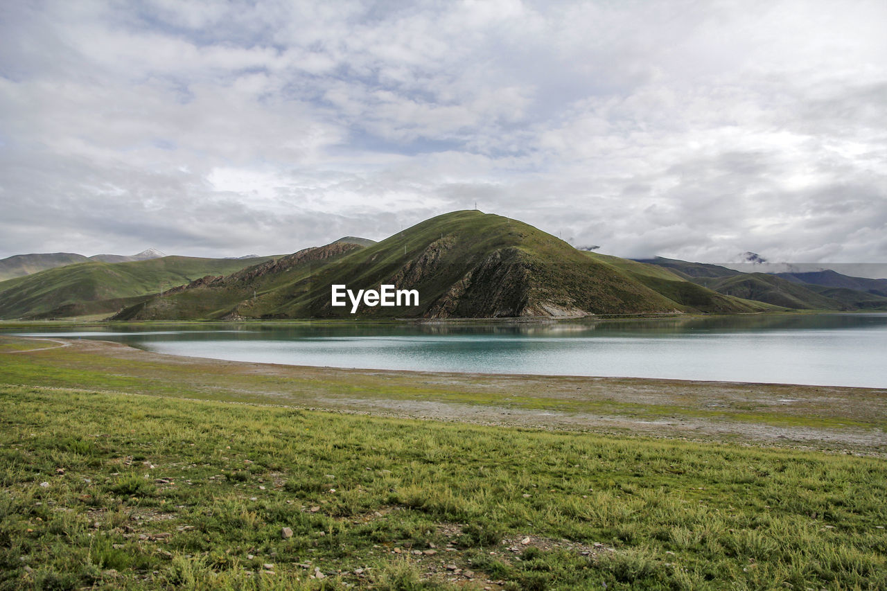 highland, lake, mountain, environment, landscape, cloud, scenics - nature, sky, land, beauty in nature, water, nature, grass, coast, travel destinations, plant, reservoir, no people, tranquility, non-urban scene, travel, tranquil scene, volcano, grassland, horizon, green, tourism, day, outdoors, wilderness, shore, plateau, rural area, beach, volcanic landscape, mountain range, plain, overcast, body of water