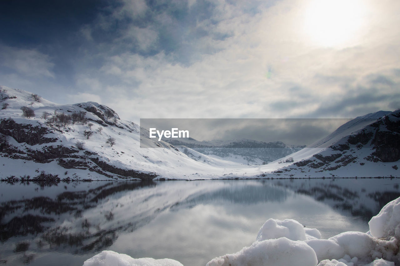 Scenic view of lake and mountains against sky