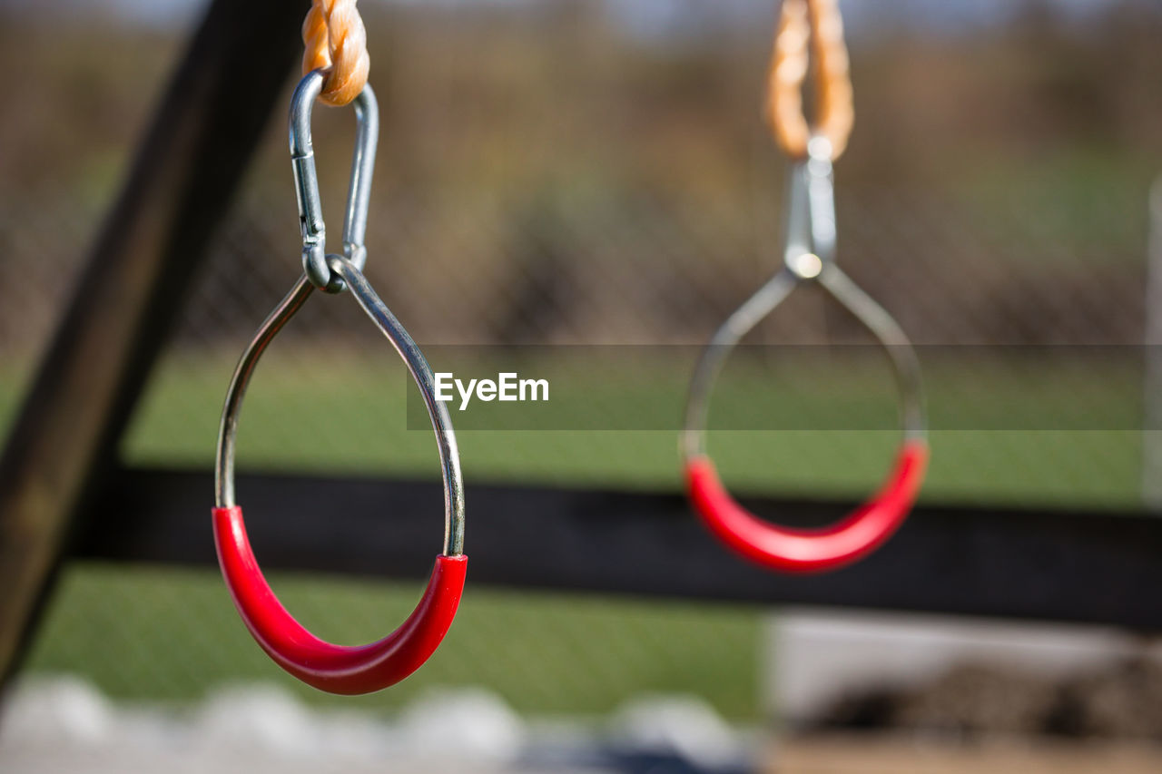 Close-up of handles hanging in jungle gym at playground