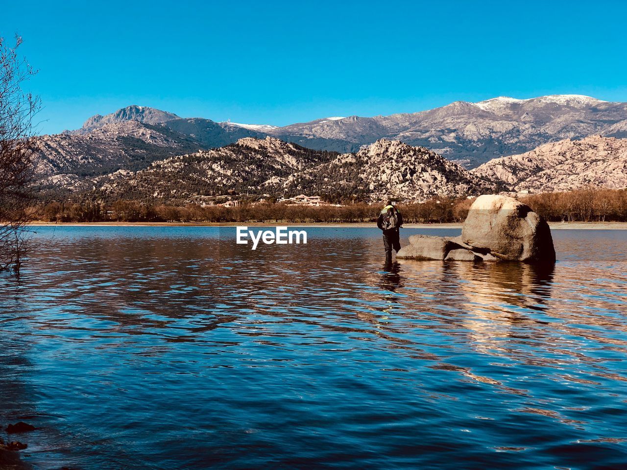 Scenic view of lake and mountains against blue sky