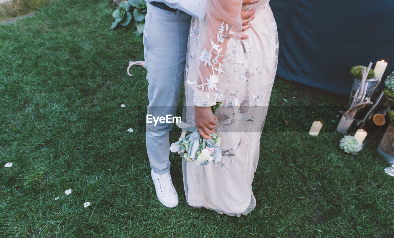 High angle view of newlywed couple embracing on field