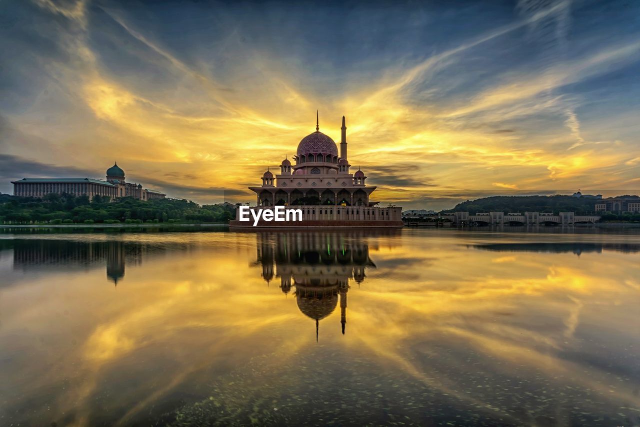 Reflection of mosque in water at sunrise